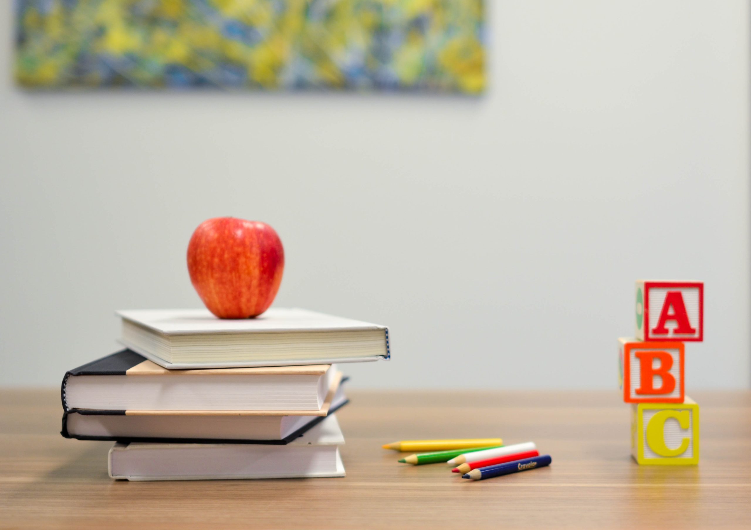 Books, alphabets, and an apple on a study table
