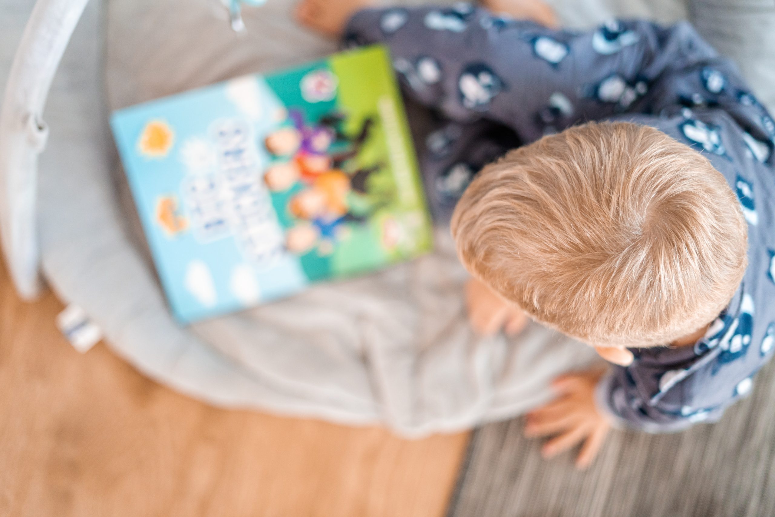 Boy reading a book in his sleeping pajamas