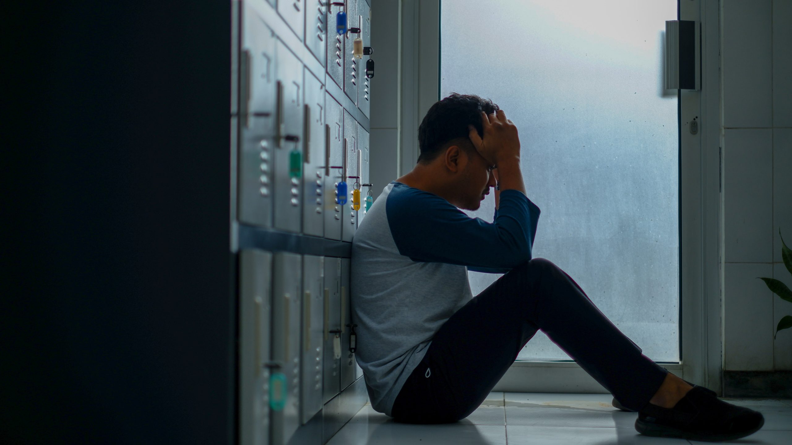 Sad boy sitting on the school floor - Depression in Teenagers