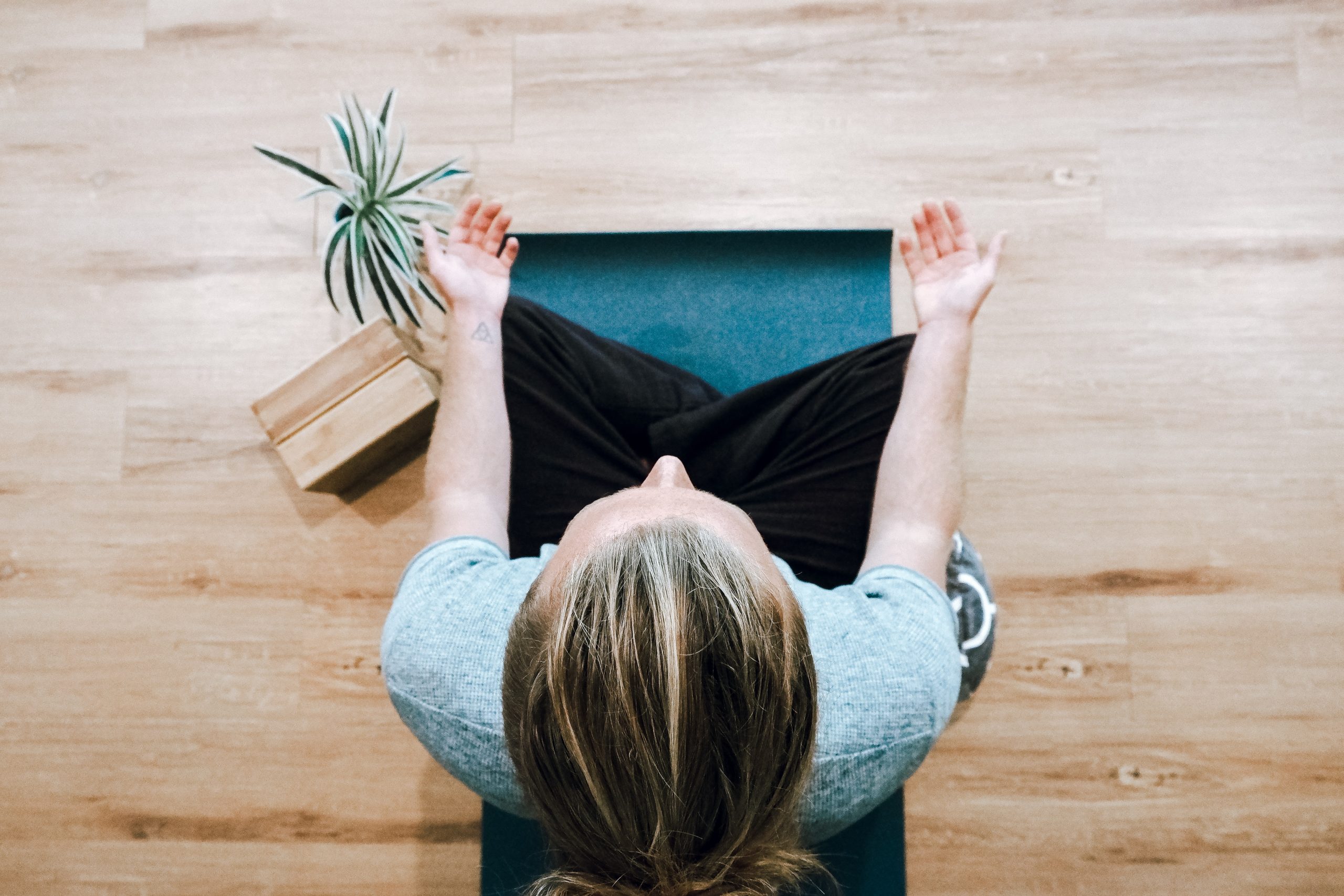 Woman sitting on wooden floor - meditation & yoga