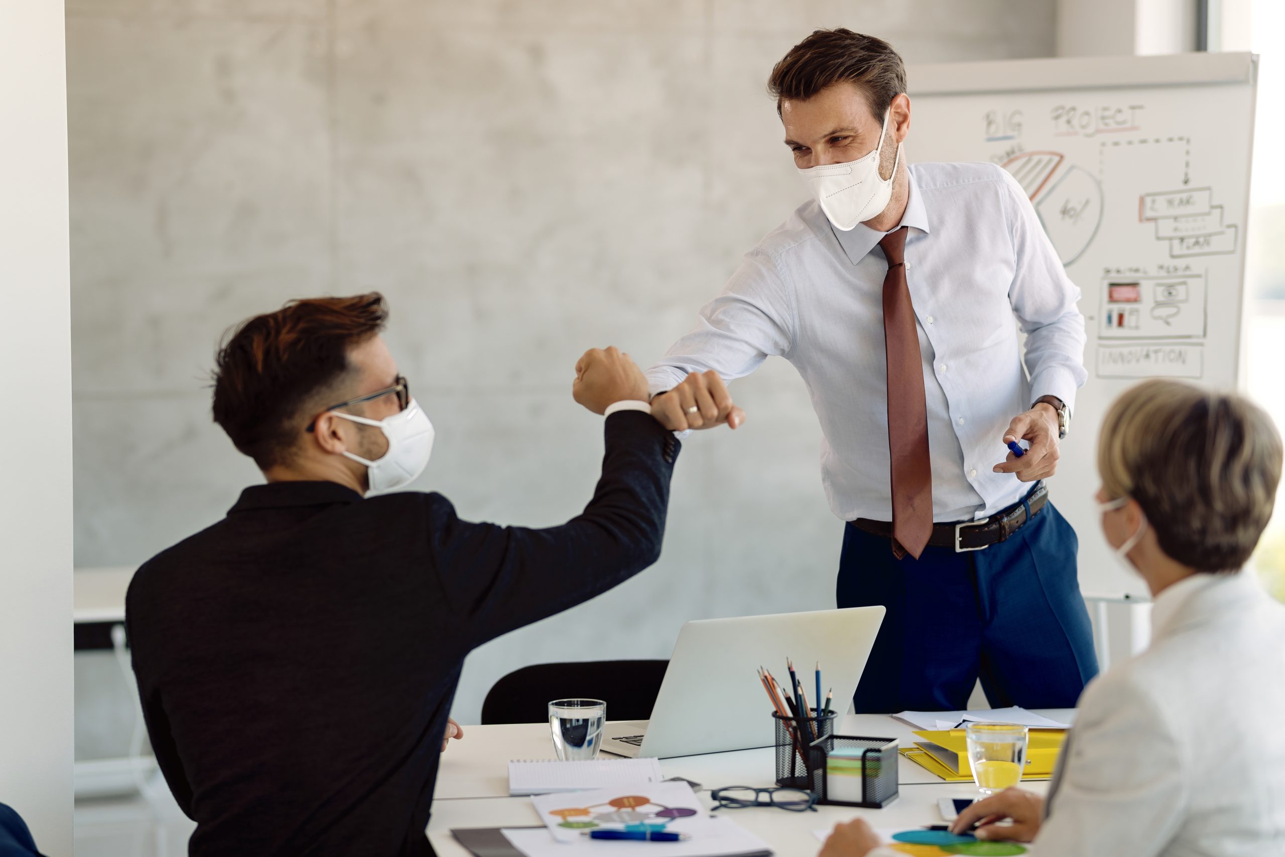Two persons wearing facemask greeted positively after presentation