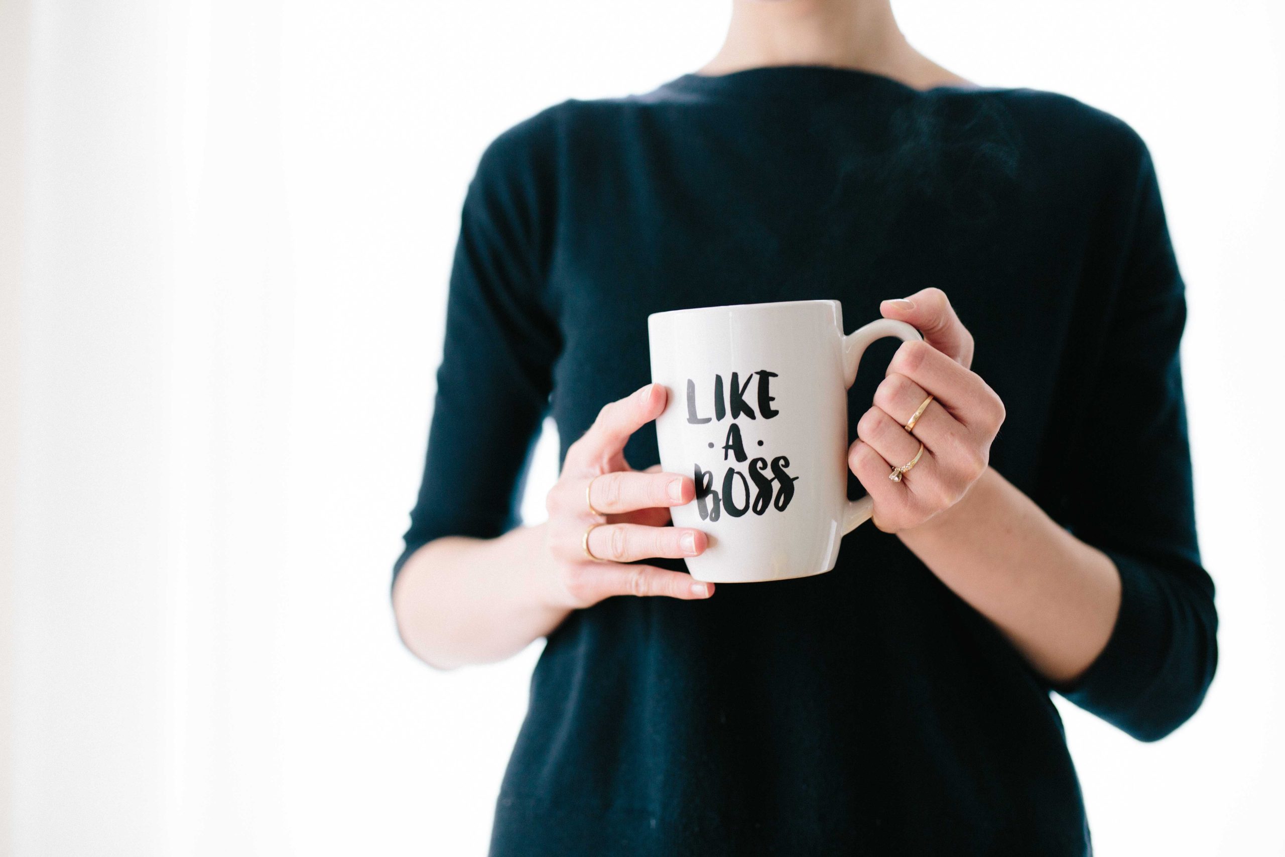 Woman holding a white mug that reads in black, 'Like a Boss'. How to Build self-esteem and confidence. Hope and Belief