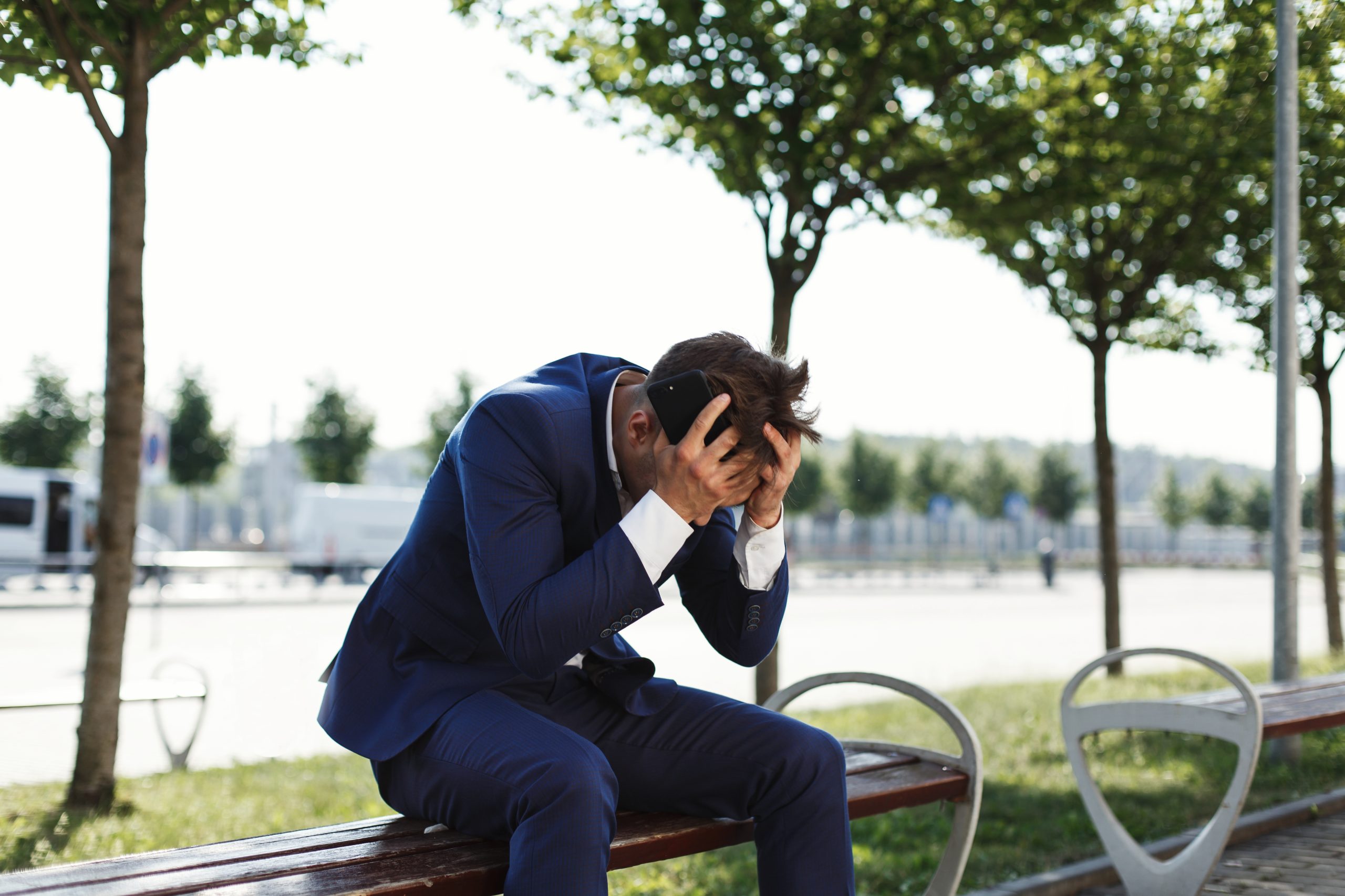 A man sitting on the bench looking sad due to job loss and unemployment